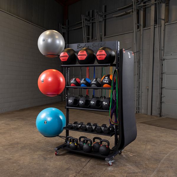 Organized gym rack with exercise balls, kettlebells, dumbbells, and resistance bands.